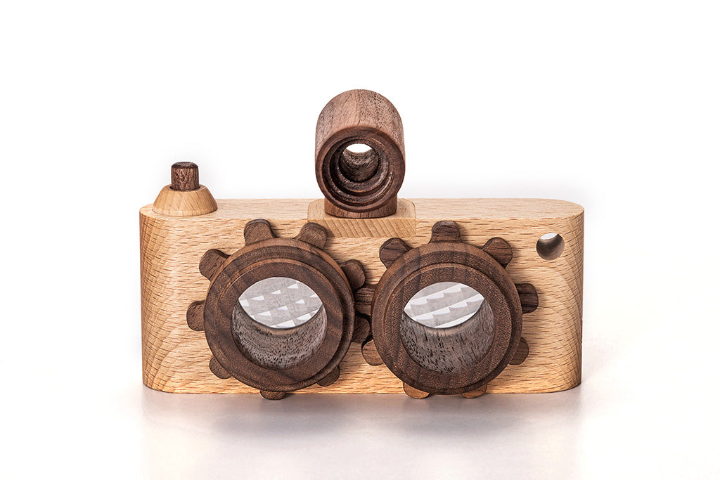 A handcrafted Twinkle Kaleidoscopic Camera model with intricate details. It features round, kaleidoscopic lenses and a viewfinder made of wood. The body of the camera has a smooth, polished finish, showcasing the natural grain and color variations of the wood.