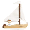 Introducing the Wooden Sailing Boat & Captain: a beautifully handcrafted wooden toy sailboat featuring white fabric sails and a charming small sailor figure, ideal for sparking imaginative play. The boat is adorned with "la mer" written on its side.