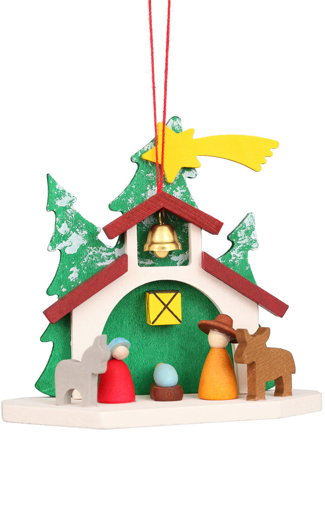 This exquisite Christian Ulbricht Ornament - Nativity, crafted in Germany, showcases a wooden Nativity scene adorned with vibrant figurines under a festive green and red roof. A radiant yellow star tops the scene, complemented by a delicate bell hanging centrally, all beautifully framed by two trees in the backdrop.