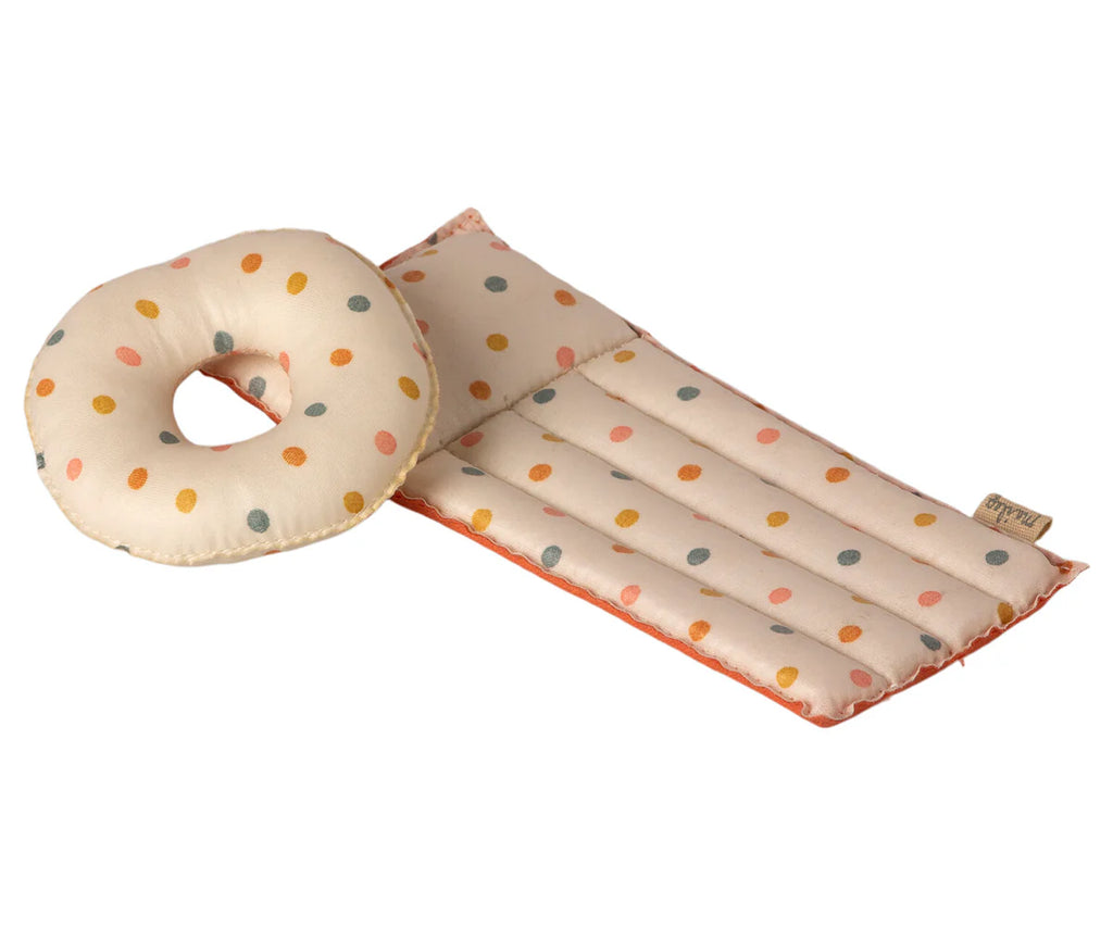 A rectangular padded baby changing mat and a matching donut-shaped cushion are shown, both crafted from coated fabric. The items, similar in appearance to the Maileg Beach Float, Mouse - Multi Dot, are cream-colored with a pattern of colorful polka dots in shades of yellow, blue, and pink.