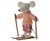 A small gray mouse figure wearing a pink knitted sweater and plaid pants stands on brown skis from the Maileg Christmas Ski and Ski poles For Big Sister & Big Brother set, holding ski poles. The charming mice toy has large ears and a long tail, exuding a cozy, playful winter activity vibe.