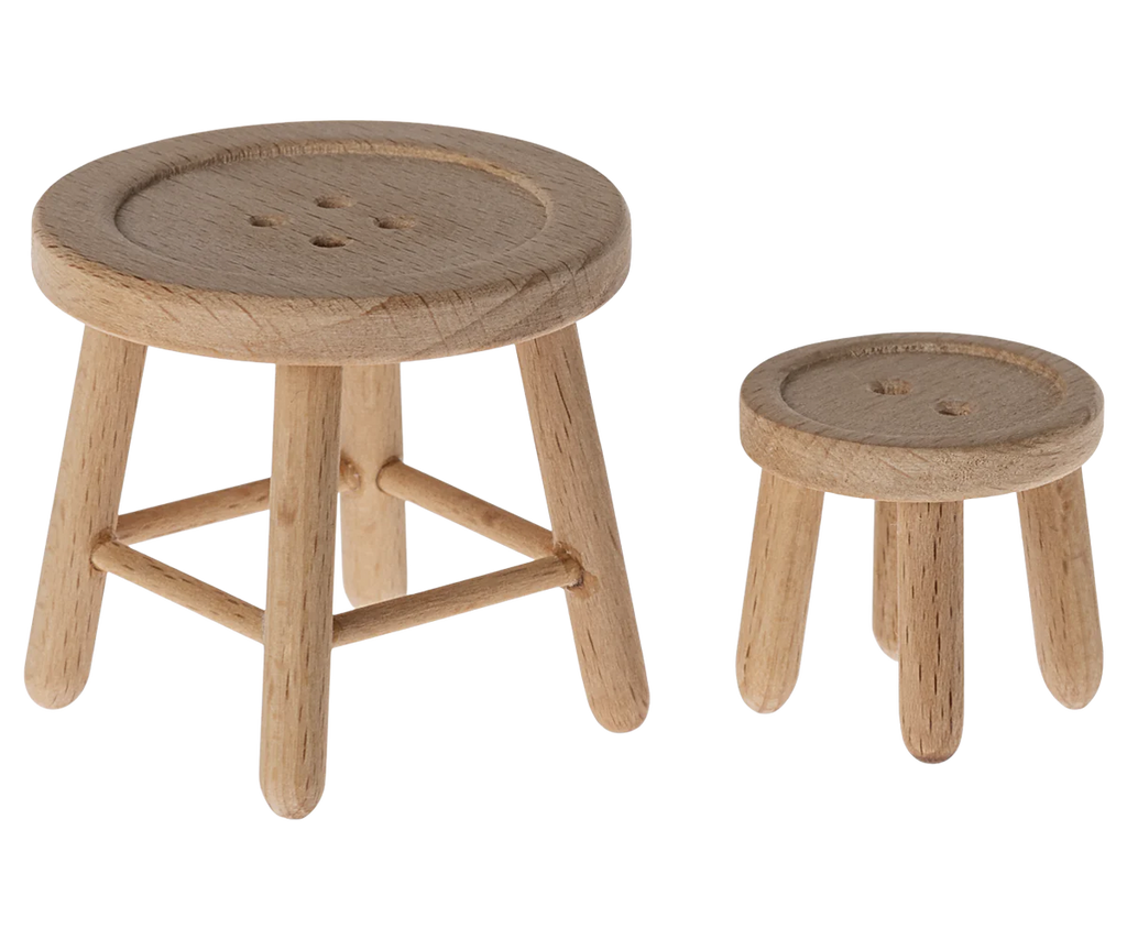 Two wooden stools with round, button-like seats bring rustic charm to any space. The larger stool boasts four legs with diagonal supports, while the smaller stool stands on three legs. Picture them nestled in a cozy corner beside your Maileg Christmas Set for holiday surprises.