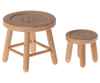 These two wooden stools, featuring different sizes and resembling oversized buttons with four holes on their tops, come with simple, light-colored wooden legs and no backrests. They present a minimalist and rustic appearance, making them perfect for imaginative play or as part of the charming Maileg Set - Sleepover At Grandparents for Grandparents Mice.