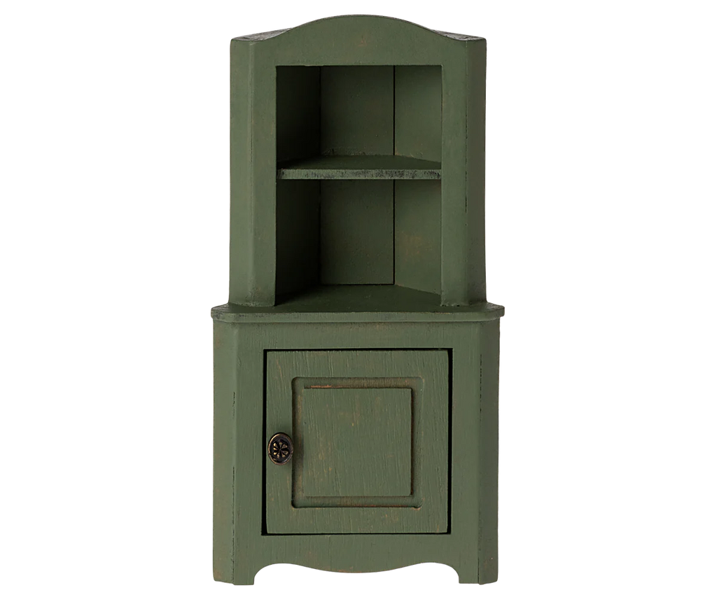 The Maileg Corner Cabinet, Mouse - Dark Green is a compact wooden shelf unit with an upper open section featuring two shelves and a lower section with a single door. The door includes a decorative round knob, which highlights its vintage finish. This cabinet's rustic, vintage appearance makes it ideal for stylish home decoration.