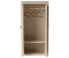 The Maileg Mouse Closet in a cream color is a compact, open wardrobe featuring two shelves, a rail with three golden hangers, and a straightforward, minimalist design.