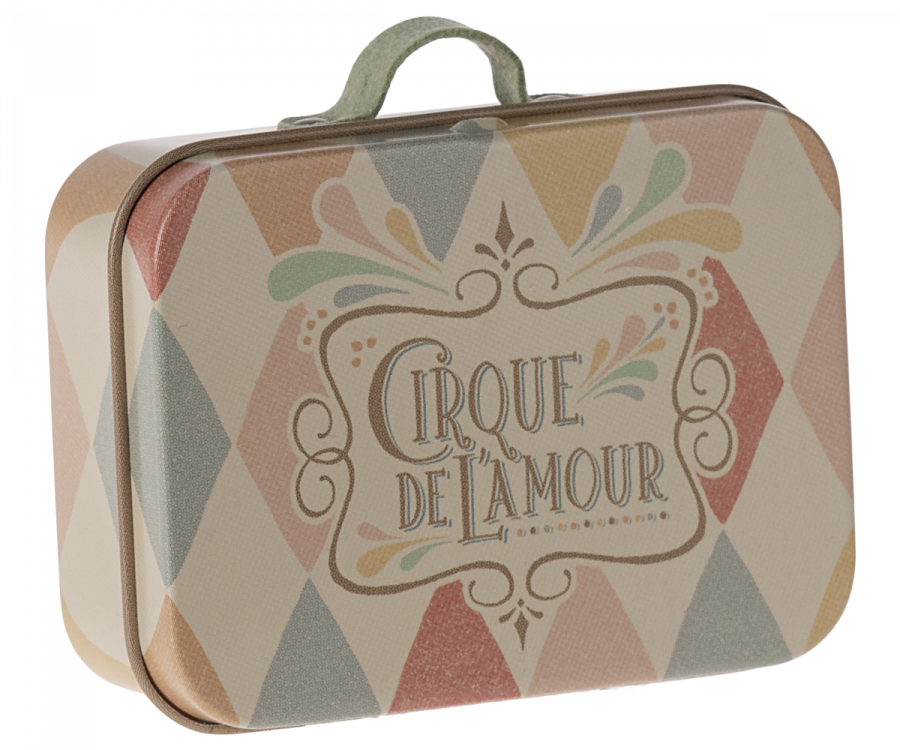 The Maileg Suitcase, Micro is a small rectangular metal box with a handle on top, resembling a mini metal suitcase. It is adorned with a vintage-style pattern featuring pastel-colored triangles and vibrant illustrations. At the center, a label reads "Cirque de l'Amour" in soft shades of pink, green, and cream—ideal for storing small items.