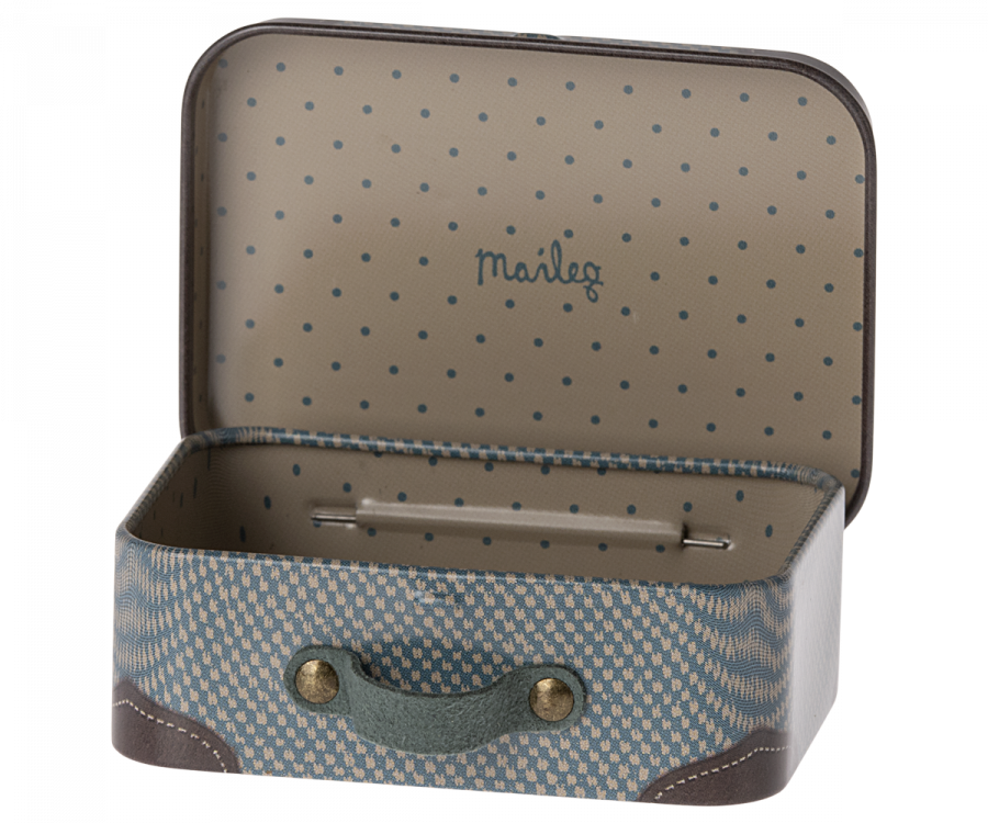 The Maileg Suitcase, Micro is a small metal suitcase featuring a blue and beige polka dot interior and a blue wavy pattern exterior. Ideal for storing small items, it comes with a grey handle accented by brass buttons and has the word "Maileg" printed on the inside of the lid.