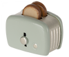 A Maileg | Miniature Toaster - Mint with two slices of toasted bread popping out, viewed from a slightly angled side perspective, emphasizing the toaster's dial and lever.