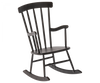 A dark wooden Maileg Rocking Chair, Mini - Anthracite with a high back featuring vertical slats, curved armrests, and a gently curved seat. The rockers at the bottom are also wooden, matching the rest of the teddy family furniture in material and color.