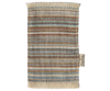 The Maileg Striped Rug, Small showcases a textured design with multicolored stripes and earthy shades of brown, green, and beige. It includes fringe on the top and bottom edges, making it perfect for use as a door mat in entryways. There is also a small tag attached to the right side.