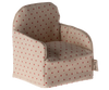 Introducing the Maileg Chair, Mouse - Dot: a delightful, small beige fabric armchair adorned with red polka dots. This charming piece features a rounded back and includes a little tag on the side, capturing the whimsical essence of a gingerbread house. It's an ideal addition to your Maileg chair collection and perfect for small Maileg friends to relax in style.