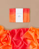 A folded Sarah's Silk Giant Fire Playsilk, showcasing a gradient of orange to red hues, is displayed on a beige background. Below it, the playsilk is unfolded and draped, highlighting the smooth, vibrant fabric perfect for open-ended play. The label on the folded playsilk reads "Sarah's Silk Giant Fire Playsilk," inspiring imaginative adventures.