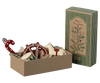 The Maileg Peter's Christmas Ornament Set (2024) features an attractive cardboard gift box adorned with charming ornaments such as a candy cane, horse, drum, and heart shapes. The box is lined with paper and is accompanied by a matching upright rectangular package.