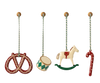 The Maileg Peter's Christmas Ornament Set (2024) features four delightful ornaments on striped strings: a red pretzel, a green and white drum, a white rocking horse, and a red candy cane. Each metal ornament is attached to a small decorative knob, adding a touch of festive charm to any gift box or holiday display.