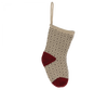 A decorative Maileg Christmas Stocking in soft grey with a textured pattern hangs against a black background. The heel and toe are dark red, enhancing the festive appearance. A convenient loop at the top makes it ideal for holding small gifts, adding charm to your holiday decor.