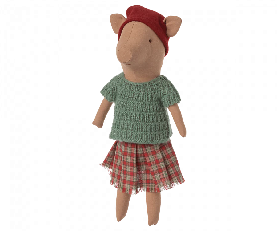 The Maileg Christmas Pig - Girl is a cozy pig plush toy dressed in a festive red hat, green knitted sweater, and a plaid skirt, making it perfect for the holiday season.