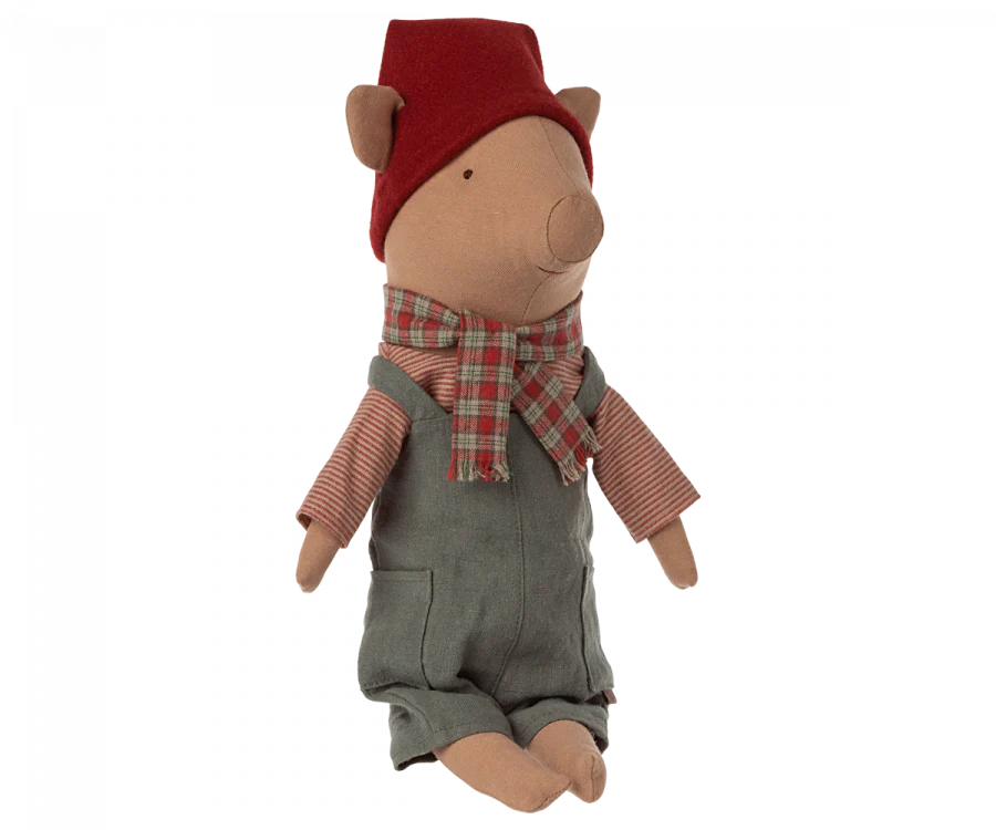 The Maileg Christmas Pig - Boy, dressed in gray overalls, a red and green plaid scarf, and a removable hat, features a light brown body and a round snout, giving it a whimsical and charming appearance. This adorable stuffed animal makes the perfect holiday decoration.