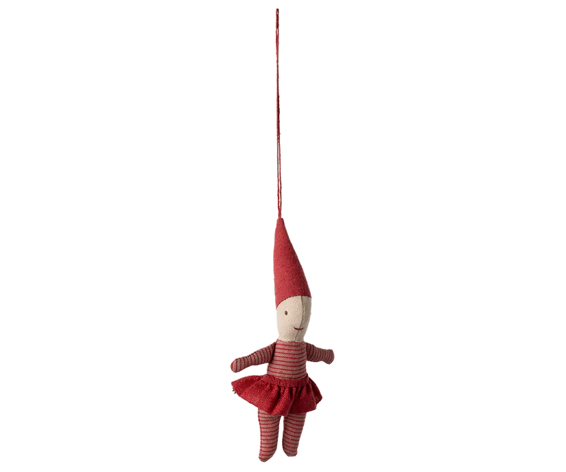 The Maileg Pixy Ornament - Girl is a charming fabric elf doll that hangs by a red string. Dressed in a striped red outfit and pointed hat, it features an exclusive look with its simple embroidered face and outstretched arms, making it perfect for adding whimsy to your Christmas tree ornaments collection.