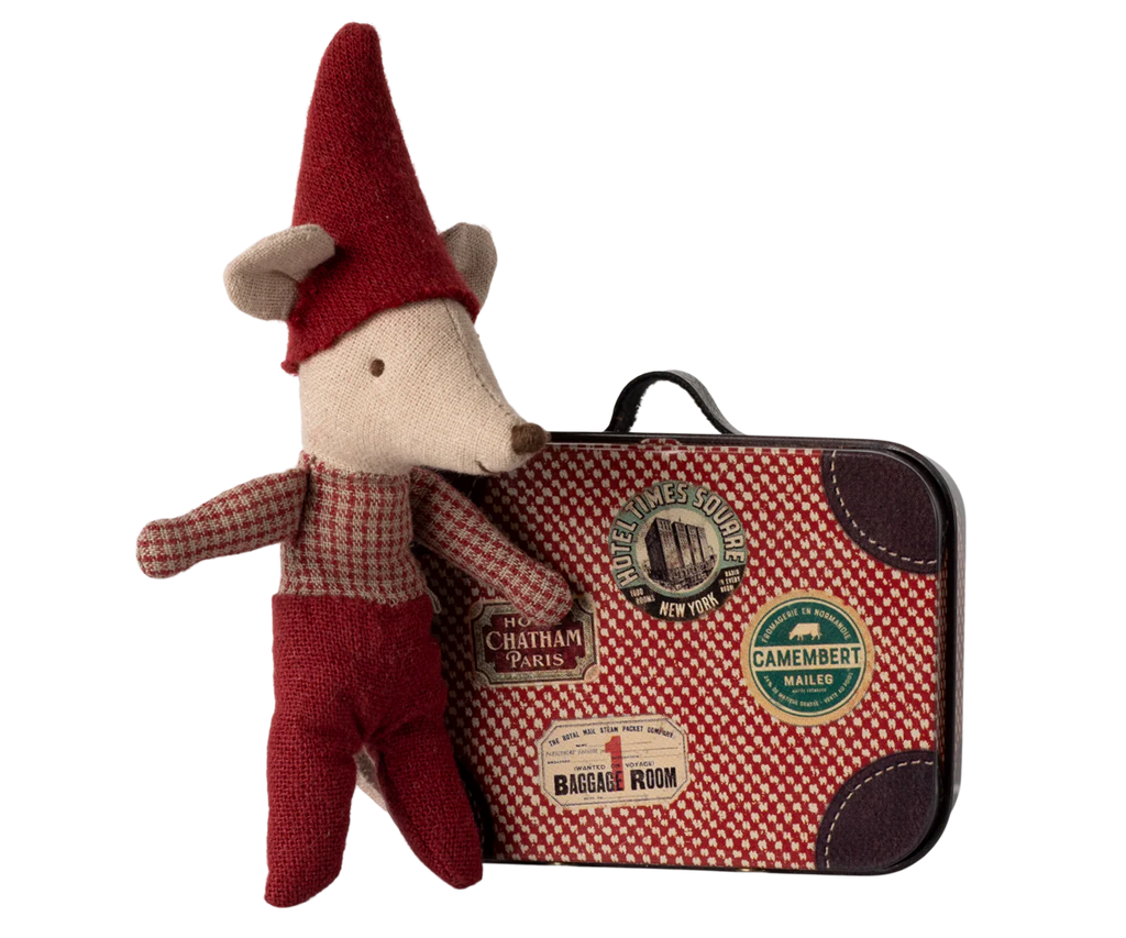 The Maileg Christmas Mouse, Baby in Suitcase, dressed in red clothing and a pointed hat, stands beside a travel suitcase adorned with stickers such as "Chatham Paris," "Camembert Maille," and circular stamps, creating a festive scene.