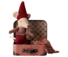 The Maileg Christmas Set features a small plush mouse dressed in a red hat and matching outfit, posing in a vintage-designed miniature suitcase adorned with geometric patterns and metal studs. This set includes a red-checked blanket but poses a potential choking hazard for children under three.