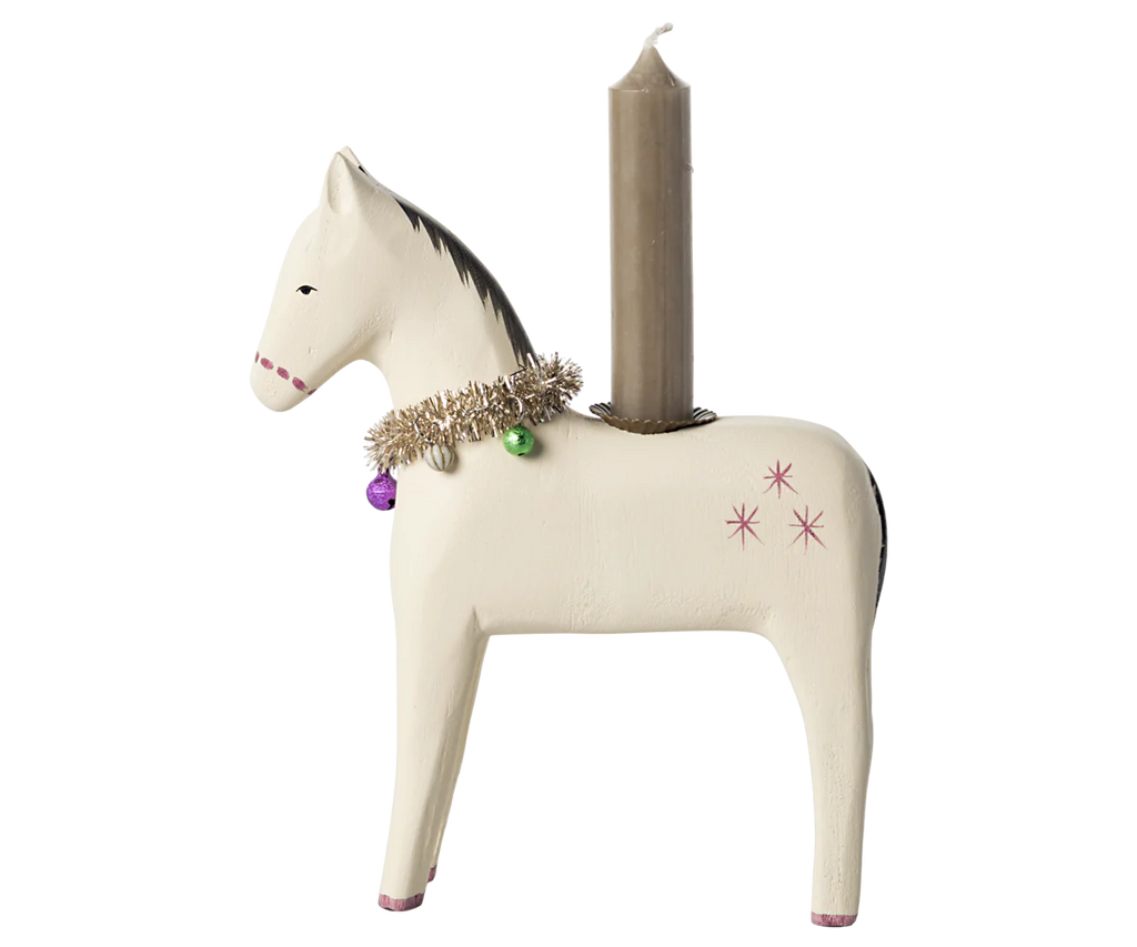 The Maileg Wooden Horse Candle Holder - Large is a classic piece featuring a beige finish with small pink stars and a tinsel garland. It is designed to hold a tall, unlit brown candle on its back, making it an ideal addition for creating a cozy Christmas atmosphere.