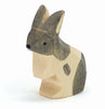 A small wooden rabbit figurine with a minimalistic design. Handcrafted from sustainably sourced materials, the rabbit is painted in natural wood tones with black and white accents, featuring simple facial details and a smooth, polished finish. The figure is depicted in a standing position, reminiscent of Ostheimer wooden toys, specifically the Ostheimer Black & White Rabbit - Standing.