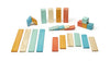 An assortment of colorful Tegu 24 Piece Magnetic Wooden Block Set - Sunset blocks of different shapes and sizes, standing and lying on a white surface.