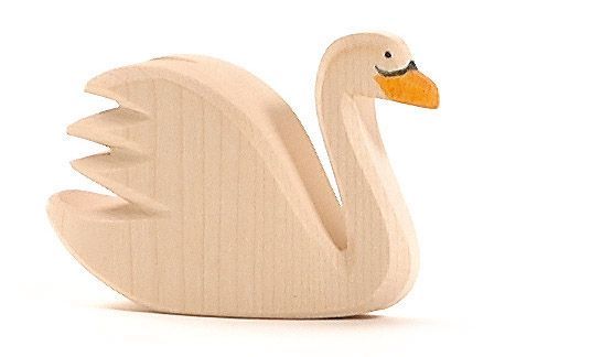 The Ostheimer Swan is a light wooden figurine shaped like a swan with simplified details, echoing the classic design of Ostheimer toys. It features a yellow beak, small black eyes, and intricately carved wings. The wood remains unpainted except for the beak and eyes, giving it a natural, minimalist look ideal for imaginative play.