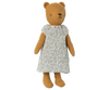 A brown plush bear, fondly known as Teddy Mum, is dressed in a green outfit with a white floral pattern. The bear's simple stitched face has a small nose and eyes, and its round ears add to its charm. The Maileg Extra Clothing: Nightgown for Teddy Mum, which can be purchased separately, features white lace trim on the hem and sleeves. Teddy Mum stands upright against a white background.