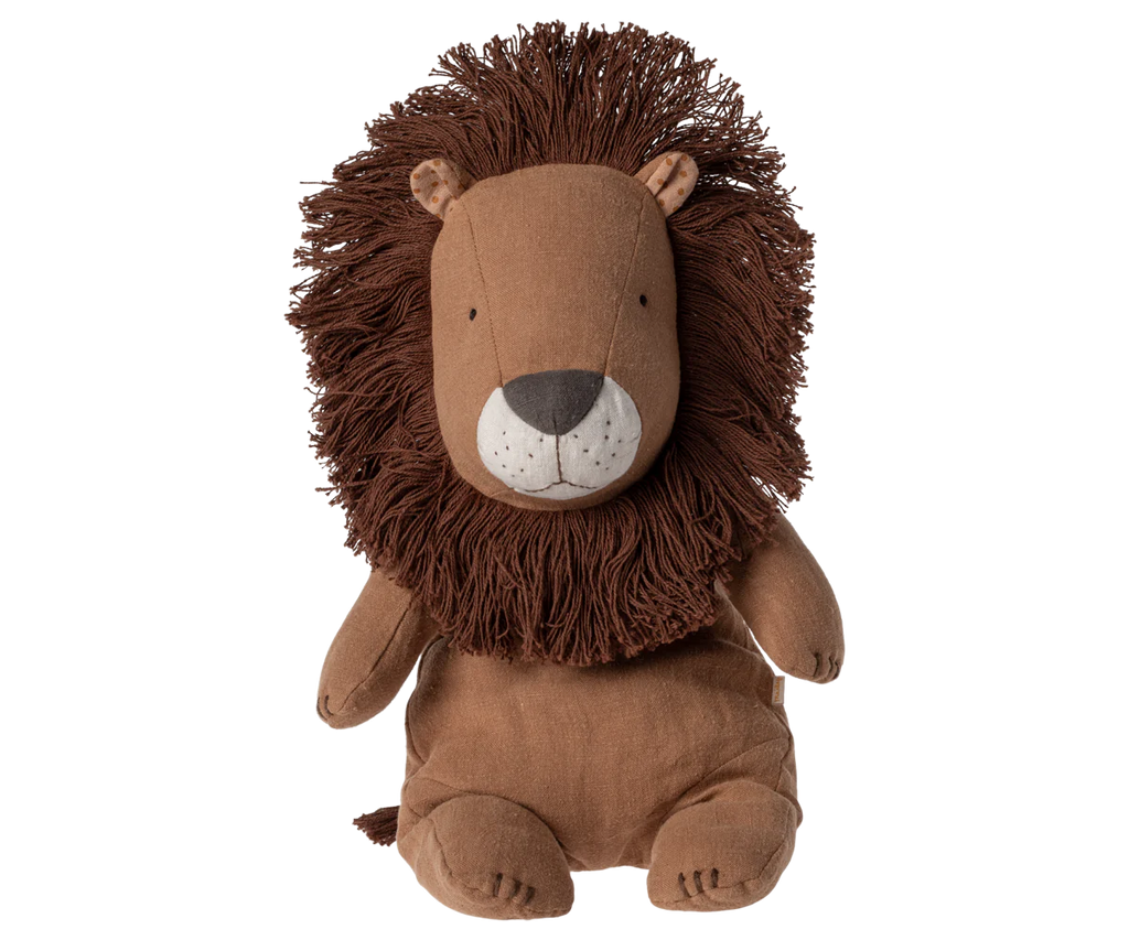 The Maileg Lion Stuffed Animal from the Safari Friends collection sits upright, featuring a brown body with a mane of thick, dark brown yarn. Its simple, embroidered face showcases small eyes and a stitched nose and mouth, highlighting exquisite handmade details.