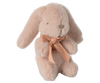 The Maileg Mini Plush Bunny - Powder is made from soft fabric and features a gentle pink hue with long, floppy ears. It boasts simple stitched eyes and nose that exude charm, while a peach satin ribbon bow elegantly adorns its neck.