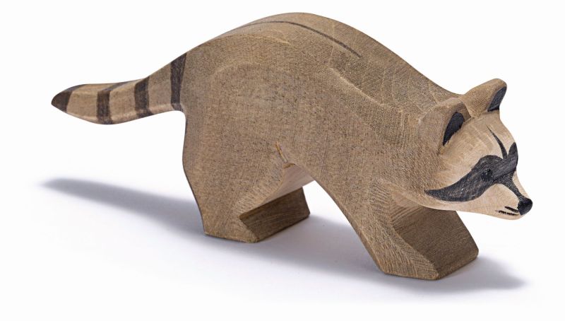 The "Ostheimer Raccoon Running" is a wooden raccoon figurine with a natural wood finish, featuring dark stripes on the tail and black markings on the face. Handcrafted to resemble Ostheimer toys, this raccoon is depicted in a standing position that appears as if it's mid-walk, making it perfect for imaginative play.