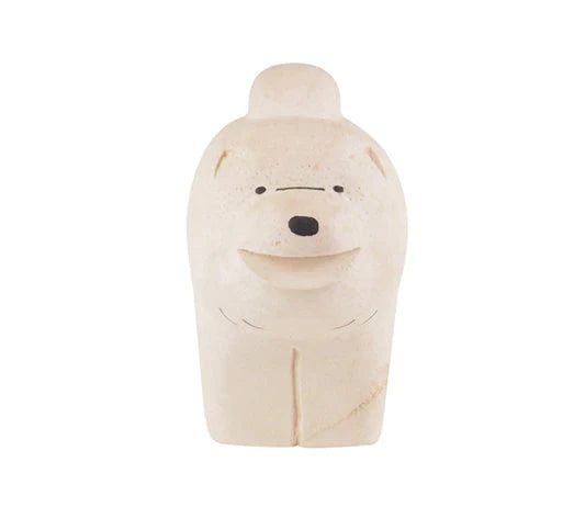 A small, beige-colored figurine of a dog crafted from Albizia wood with minimal facial features, including two small black eyes, a line representing a nose, and a simple smile. The Chow Chow dog stands upright with a rounded shape and simplistic design.