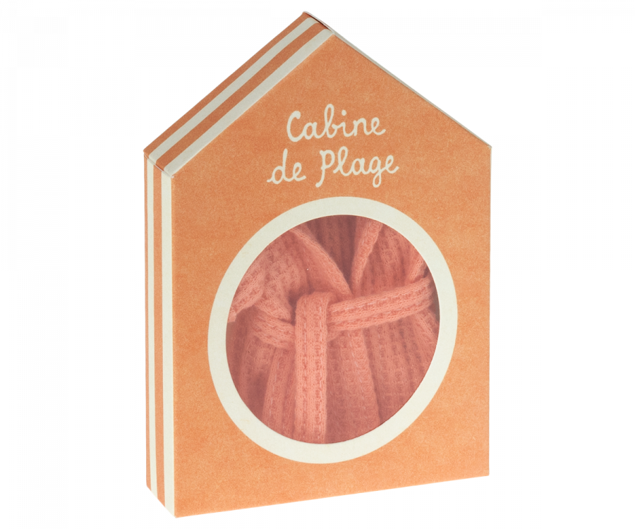 An orange house-shaped box with the text "Cabine de Plage" on it. The circular window reveals a glimpse of the Maileg Extra Clothing: Bathrobe - Coral inside. The box has a simple, charming design.