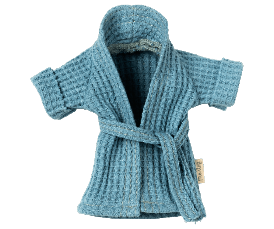 A small, blue, waffle-knit kids bathrobe with short sleeves and a belt tied at the waist. This soft Maileg Extra Clothing: Bathrobe - Dusty Blue appears designed for a child or a small stuffed animal, featuring a textured fabric and a mini tag on the left side.