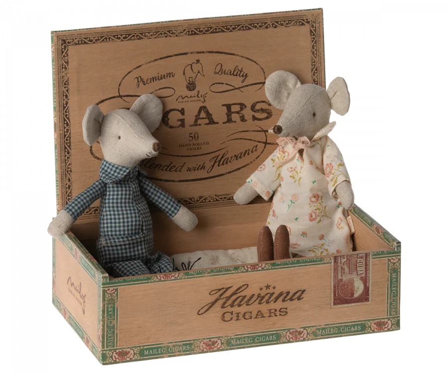 Two Maileg Grandma & Grandpa Mice in Cigarbox, one dressed in a floral dress and the other in a plaid shirt, sitting in an open cigar box labeled "Havana cigars," now repurposed with cozy bedding.