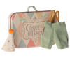 A small, decorative suitcase featuring the text "Cirque de l'Amour" along with pastel-colored patterns. Next to the suitcase are a tiny polka-dotted clown hat with an orange pom-pom and a pair of green overalls, making it a delightful travel-friendly toy accessory set, known as Maileg Clown Clothes In Suitcase, Little Brother Mouse.