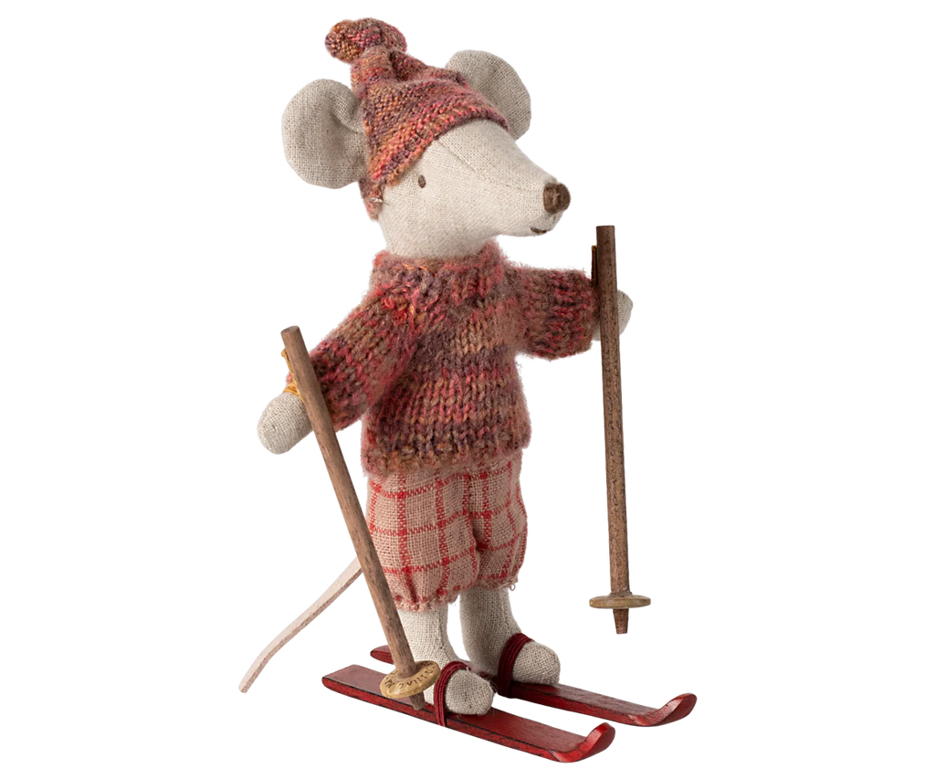 The Maileg Winter Mouse with Ski Set, Big Sister - Rose is made from recycled polyester and features a charming appearance with its knitted sweater and hat. The mouse stands on red skis, clutching ski poles, while sporting plaid pants that enhance its cozy, wintery vibe in warm earthy tones—ideal for any ski playset scene.