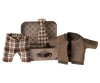 A small metal suitcase with a brown handle and a patterned interior, holding a set of miniature clothing. Inside are plaid pants, a brown jacket with a green collar, and a beige and brown checked tie—perfectly designed as Maileg Jacket, Pants And Tie In Suitcase, Grandpa Mouse.