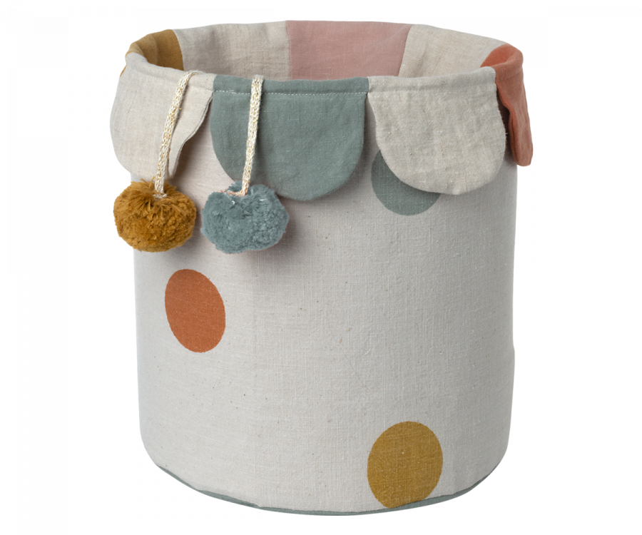 Introducing the Maileg Basket, a delightful cotton linen basket that showcases a whimsical design with colorful polka dots and elegant scalloped edges, ideal for storing toys. This charming piece is embellished with two hanging pom-poms in yellow and teal. The soft pastel hues of pink, mustard, and muted teal evoke the enchanting style of the original Maileg Basket.