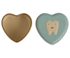 Two heart-shaped items: one is an open, empty beige container with a dark brown rim, and the other is a Maileg Tooth Box featuring a cute tooth illustration with a smiling face. The objects are side by side, evoking childhood memories, isolated on a white background.