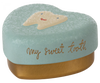 A Maileg Tooth Box with a pastel blue lid featuring a picture of a smiling tooth. The words "my sweet tooth" are written in cursive on the side of the lid. The bottom part of this metal heart keepsake is gold-colored, perfect for preserving precious childhood memories.