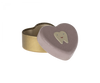 A small, heart-shaped Maileg Tooth Box with a beige base and a pink lid adorned with a smiling tooth illustration. The lid is partially open, revealing the empty inside of the container, perfect for storing small baby teeth and preserving childhood memories.