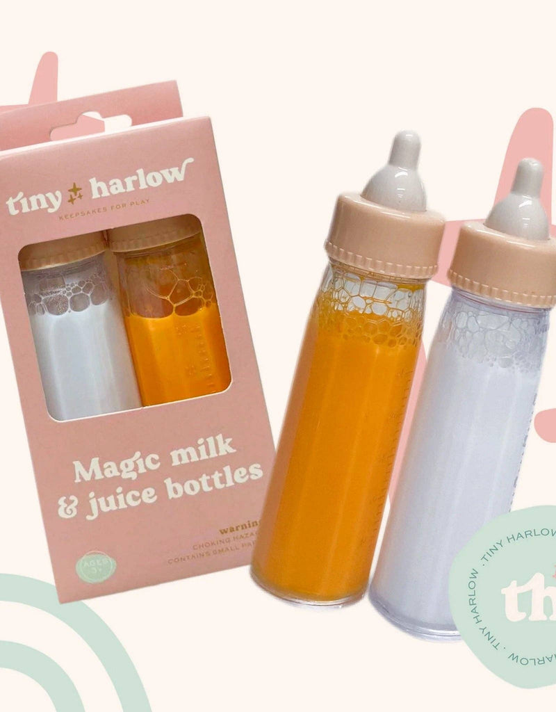 The Bottled Milk and Juice Set by Tiny Harlow features two enchanting bottles for doll feeding, filled with orange and white liquids. These "Magic Milk & Juice Bottles" are elegantly presented in a charming package with a pastel background and logo embellishments.