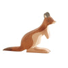 A handcrafted Ostheimer Kangaroo Father, reminiscent of Ostheimer toys, is shown in profile. The natural wood finish with varying shades of brown and beige highlights its ears, arms, legs, and long tail. Made from sustainably sourced materials, this piece stands out against the plain white background.