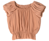 An apricot-colored, short-sleeve blouse with gathered fabric at the shoulders and an elastic band at the waist. The top has a loose fit and a round neckline, creating a ruched and textured appearance, crafted from exclusive materials found only in your Magical Wardrobe – introducing the Maileg Princess Blouse - Melon (Final Sale).