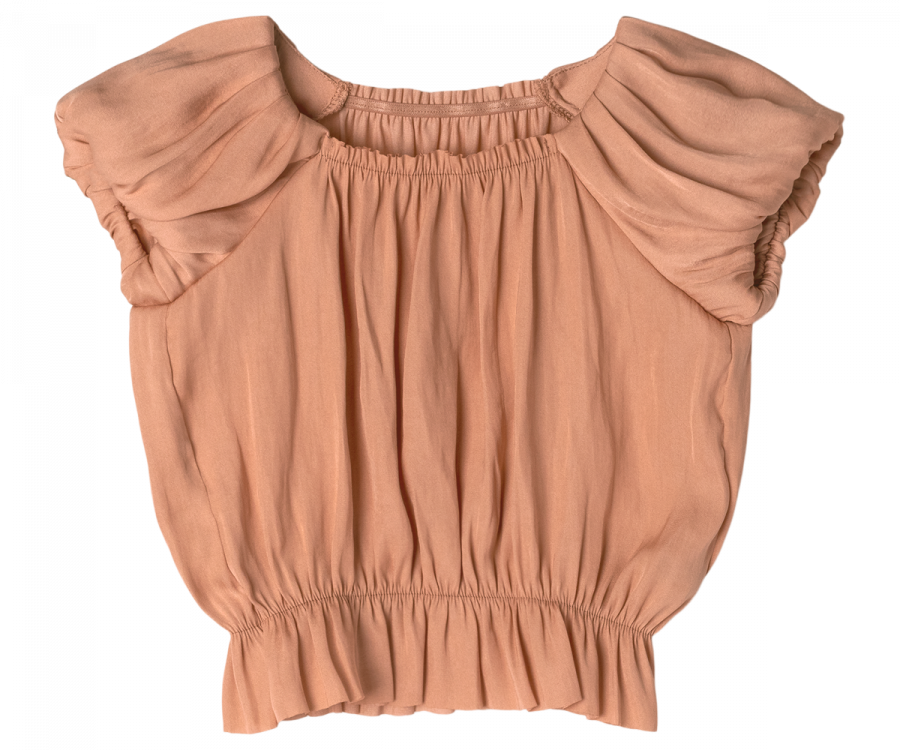 An apricot-colored, short-sleeve blouse with gathered fabric at the shoulders and an elastic band at the waist. The top has a loose fit and a round neckline, creating a ruched and textured appearance, crafted from exclusive materials found only in your Magical Wardrobe – introducing the Maileg Princess Blouse - Melon (Final Sale).