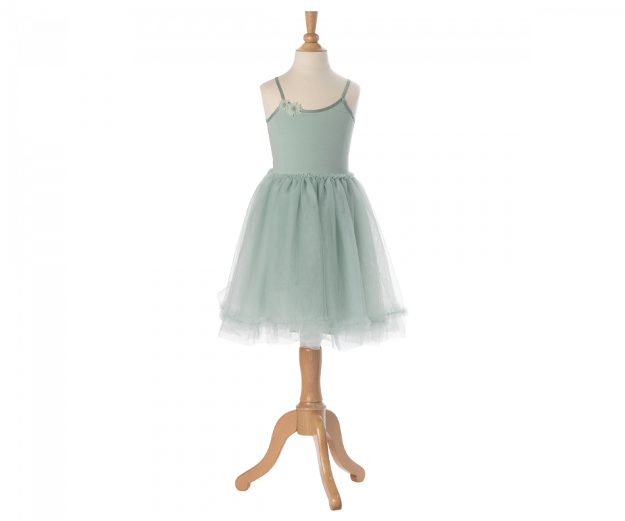 A light green, sleeveless tulle dress on a wooden mannequin stand. The dress features delicate shoulder straps and a fitted bodice, transitioning into a full, layered tulle skirt made of exclusive materials. It looks straight out of a Maileg Princess Tulle Dress - Mint. The stand has a sleek, light wood finish with an elegant design.