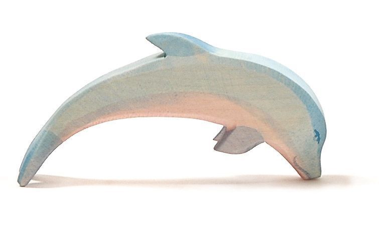 A simple, light blue and pink wooden figure called the Ostheimer Dolphin, Head Low, set against a plain white background. Handcrafted by the Ostheimer brand from sustainably sourced materials, this dolphin is shaped in a gentle curve as if it is mid-leap.