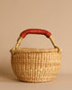 Introducing the Handmade Explore Basket, featuring a red handle and meticulously crafted from durable elephant grass in Bolgatanga, Ghana.